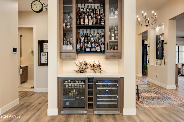 bar featuring wine cooler, hardwood / wood-style floors, and hanging light fixtures