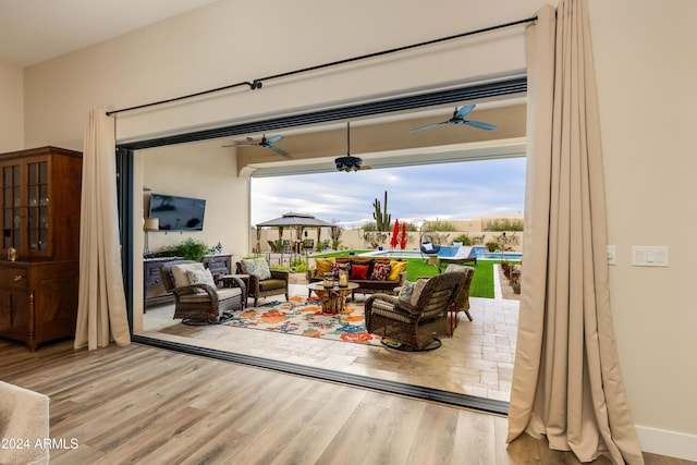 living room with hardwood / wood-style flooring and ceiling fan