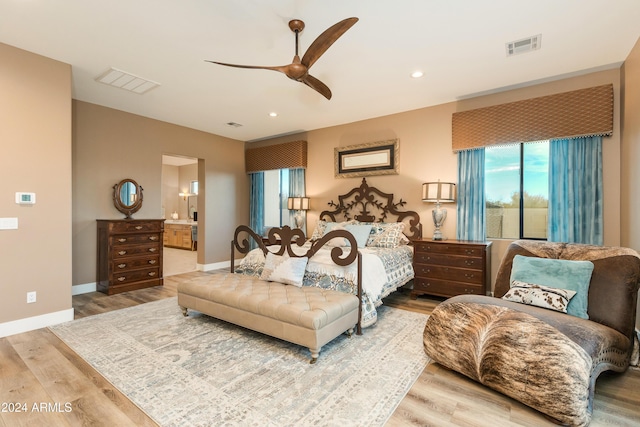 bedroom featuring ceiling fan, connected bathroom, and hardwood / wood-style floors