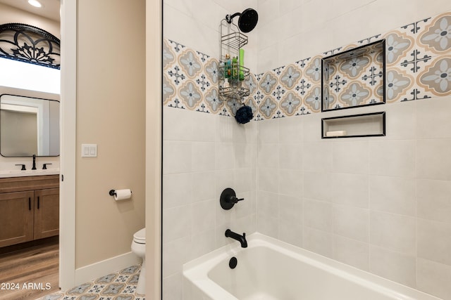 full bathroom with tiled shower / bath, vanity, and toilet