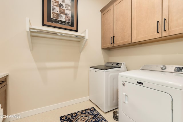 laundry room featuring cabinets and washer and dryer