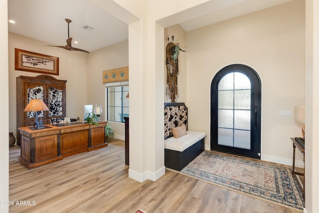 foyer entrance with ceiling fan and light hardwood / wood-style flooring