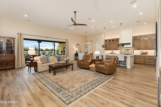 living room with ceiling fan and light hardwood / wood-style floors