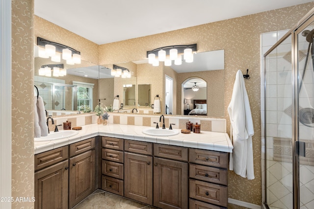 bathroom featuring ensuite bath, a stall shower, wallpapered walls, and a sink