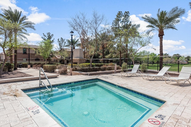 view of pool with a patio area and fence