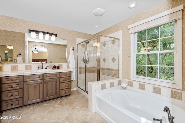 bathroom with vanity, a bath, a shower stall, and wallpapered walls