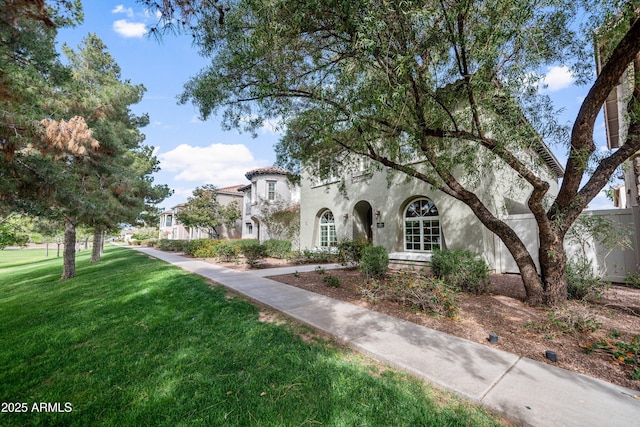 mediterranean / spanish house featuring a front lawn and stucco siding