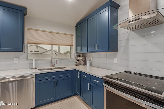 kitchen with appliances with stainless steel finishes, a sink, and blue cabinetry