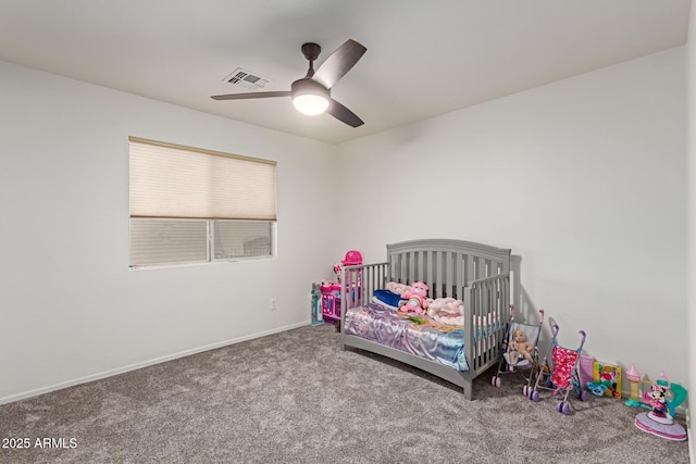 bedroom featuring visible vents, baseboards, ceiling fan, carpet flooring, and a nursery area