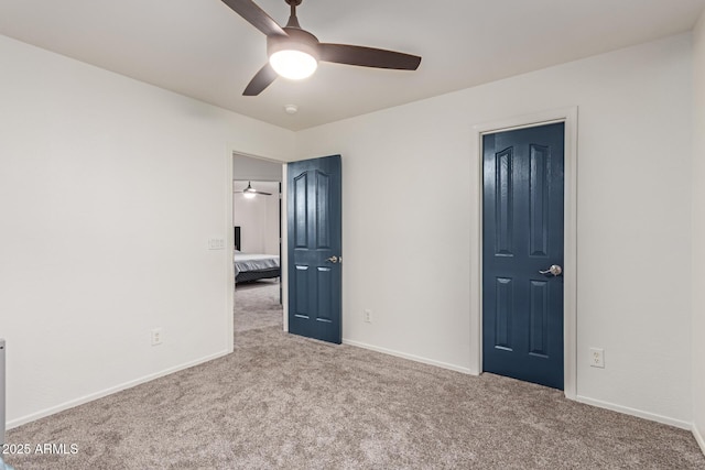 unfurnished bedroom featuring carpet floors, a ceiling fan, and baseboards