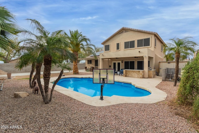 view of swimming pool with a patio area, a fenced backyard, outdoor dry bar, and french doors