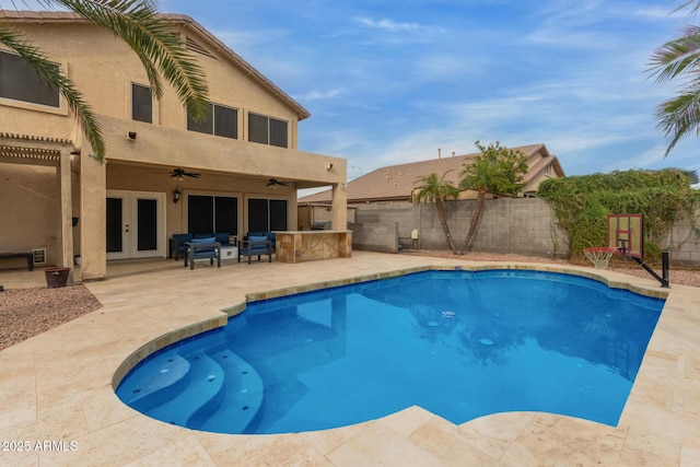 view of swimming pool with ceiling fan, fence, french doors, a fenced in pool, and a patio area