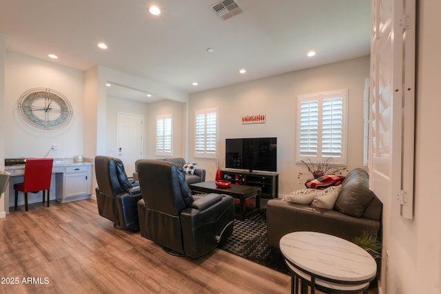 living room with a wealth of natural light, light wood finished floors, visible vents, and recessed lighting