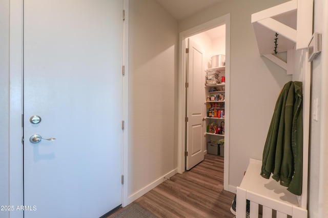 corridor with baseboards and wood finished floors