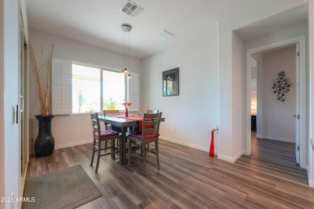 dining area featuring dark wood-style floors, baseboards, and visible vents