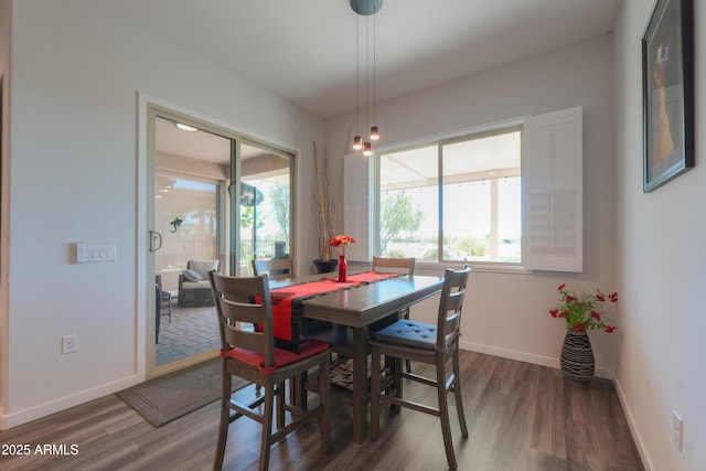 dining space featuring dark wood-type flooring and baseboards