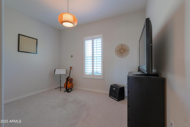 miscellaneous room featuring baseboards and light colored carpet