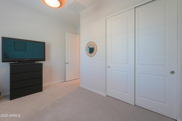 unfurnished bedroom featuring light carpet, baseboards, visible vents, and a closet