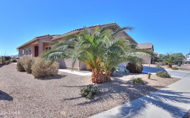 view of property exterior with a tile roof and stucco siding