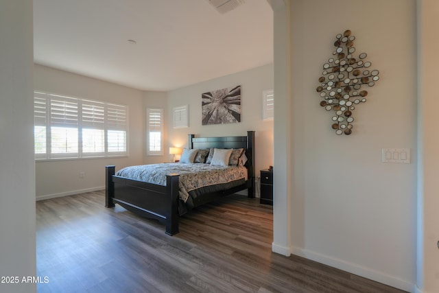 bedroom with baseboards, visible vents, and dark wood finished floors