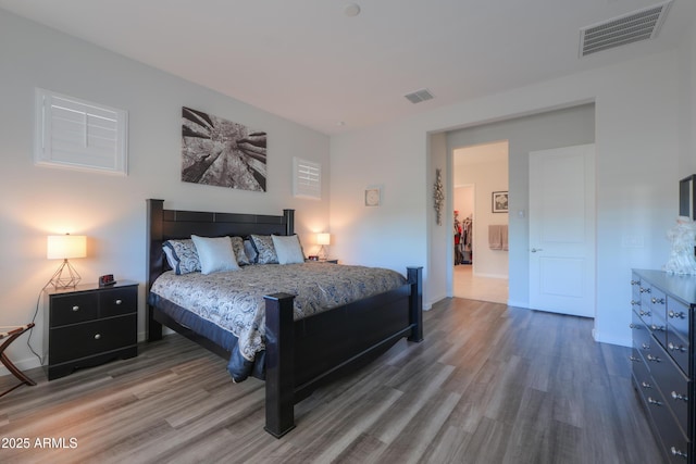 bedroom featuring wood finished floors, visible vents, and baseboards