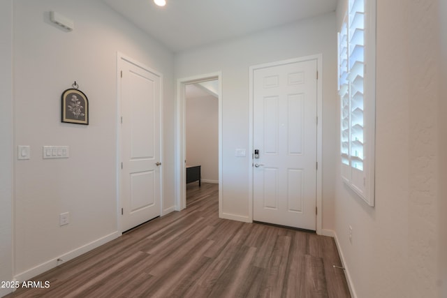 interior space with dark wood-style flooring and baseboards