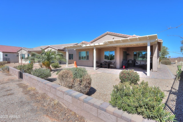 view of front of home with a tile roof, a pergola, a patio area, and stucco siding