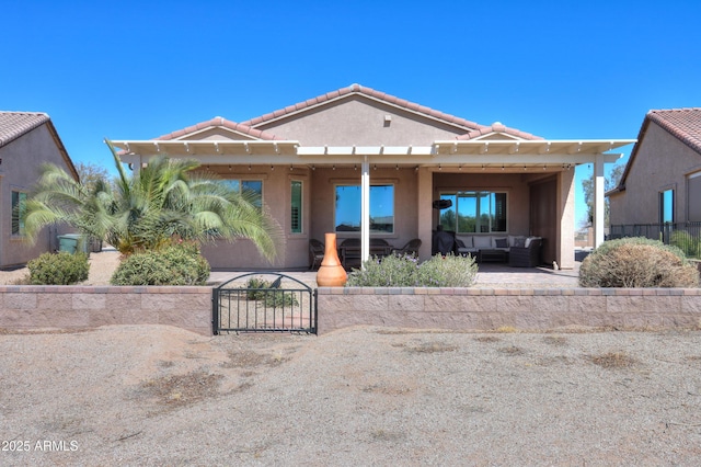 view of front of home with a patio, an outdoor hangout area, a tile roof, fence, and stucco siding