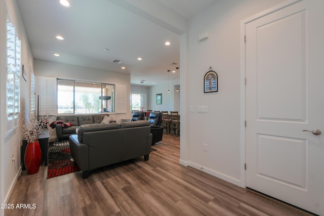 living room featuring recessed lighting, visible vents, baseboards, and wood finished floors