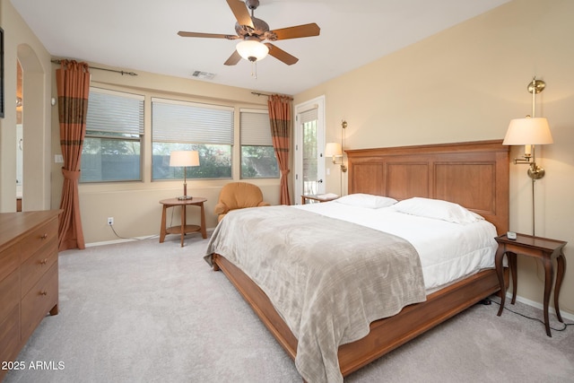 bedroom featuring arched walkways, visible vents, light colored carpet, and baseboards