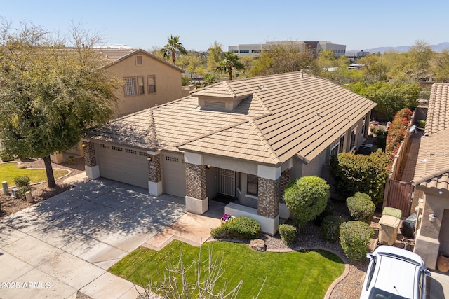 view of front of home with stucco siding, a front lawn, driveway, a garage, and a tiled roof