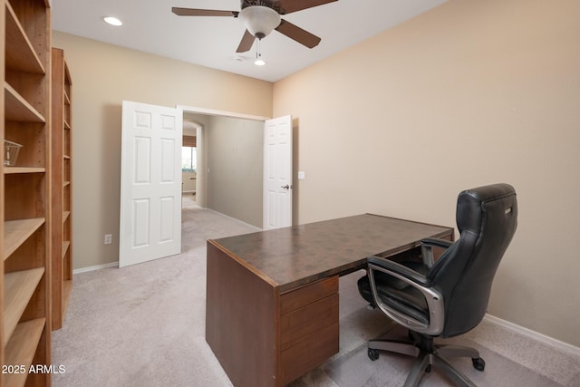 office featuring baseboards, light colored carpet, and a ceiling fan