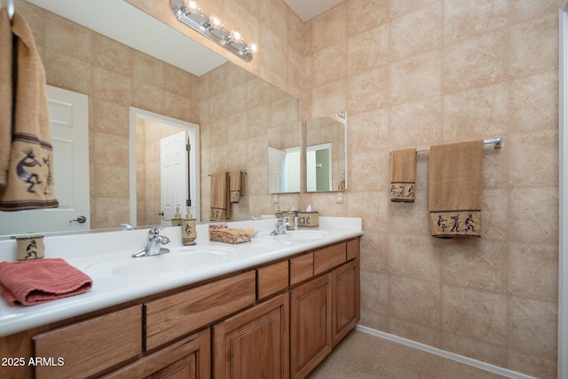 full bathroom featuring double vanity, tile walls, and a sink