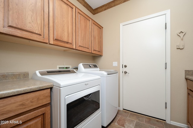 clothes washing area with cabinet space, washing machine and dryer, and crown molding