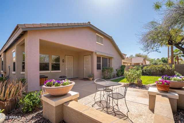 back of property featuring stucco siding, fence, and a patio area