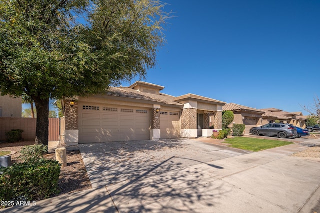 view of front facade with fence, driveway, stucco siding, a garage, and a tiled roof