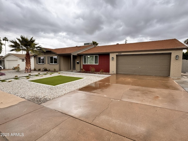 ranch-style house with brick siding, an attached garage, concrete driveway, and a front yard
