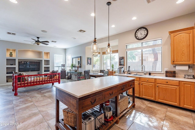 kitchen with a healthy amount of sunlight, sink, ceiling fan, and decorative light fixtures