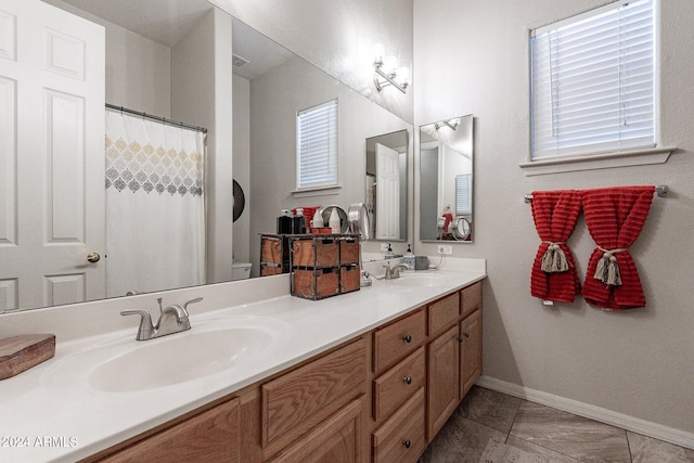 bathroom featuring vanity, tile patterned flooring, and toilet