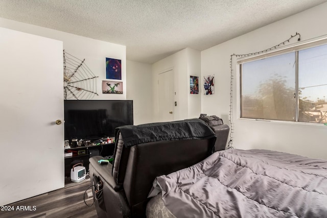 bedroom with a textured ceiling and dark wood-type flooring