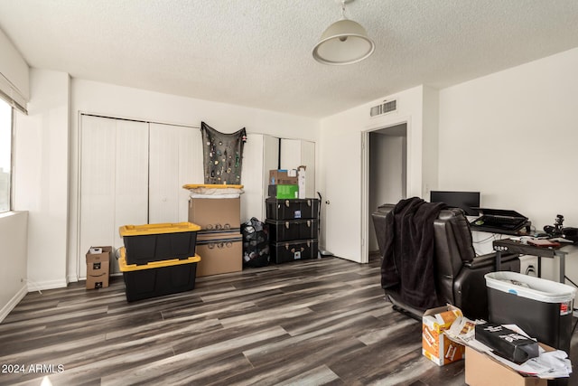 home office with dark wood-type flooring and a textured ceiling