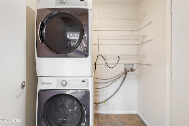 washroom with stacked washing maching and dryer