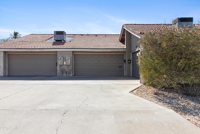 view of front facade featuring a garage and central AC unit