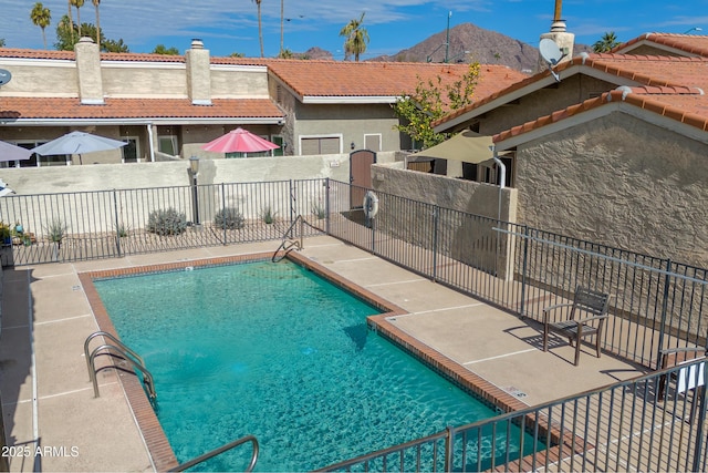 view of swimming pool featuring a patio area and a mountain view