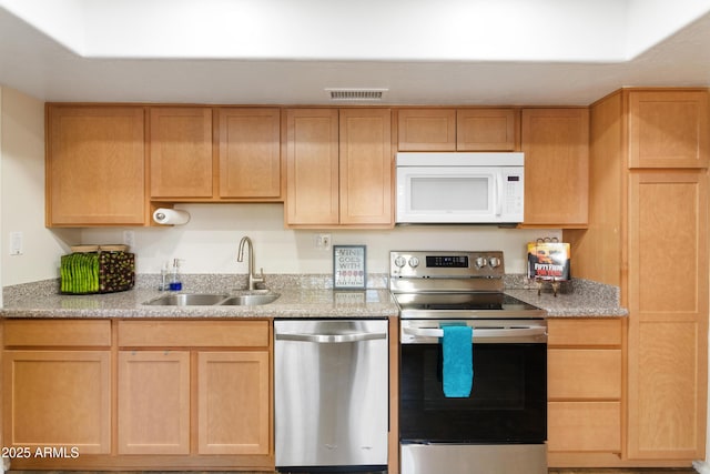 kitchen with stainless steel appliances, light brown cabinets, and sink