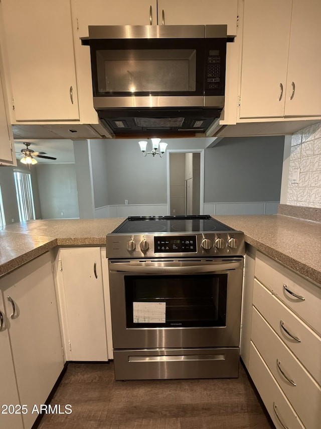 kitchen with white cabinets, light countertops, stainless steel appliances, and dark wood-style flooring