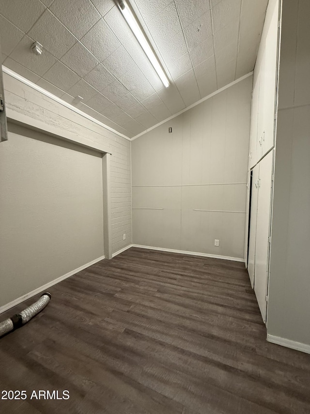 spare room with baseboards and wood finished floors