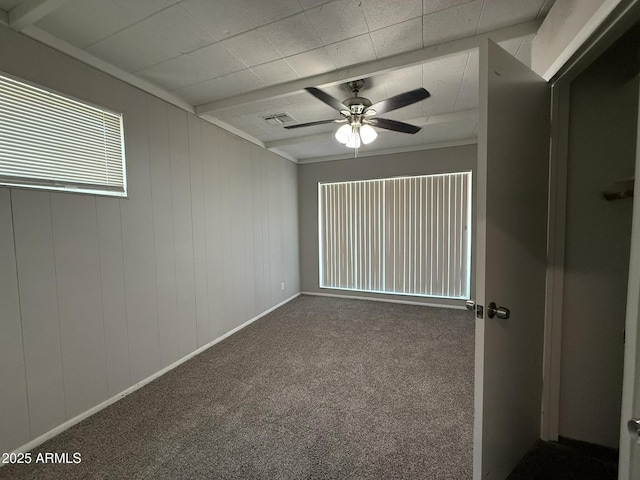 carpeted spare room with a ceiling fan and visible vents