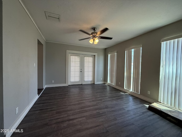 spare room with baseboards, dark wood-type flooring, french doors, and a ceiling fan