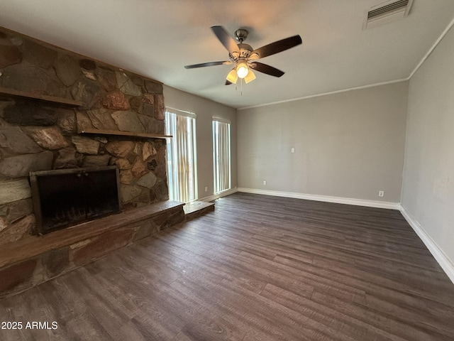 unfurnished living room featuring wood finished floors, a ceiling fan, visible vents, baseboards, and a stone fireplace